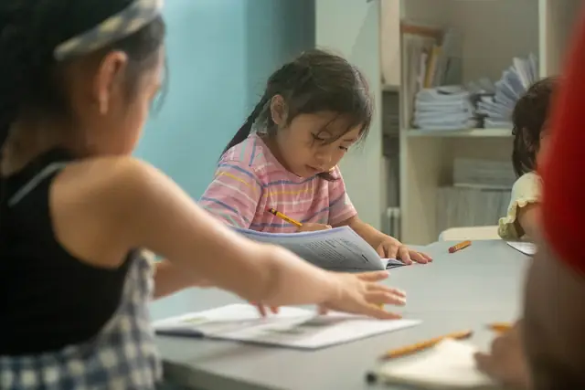 A young student concentrating on her worksheet